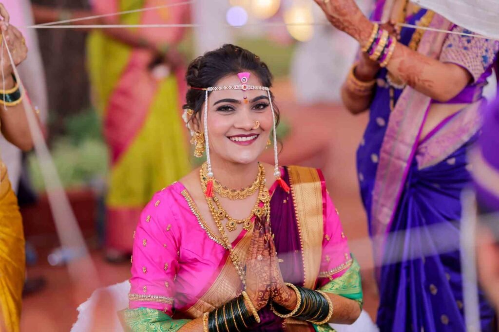 Maharashtrian bride smiling with folded hands during a wedding ritual in Lonavala